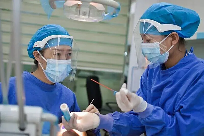 Two female doctors performing an operation.